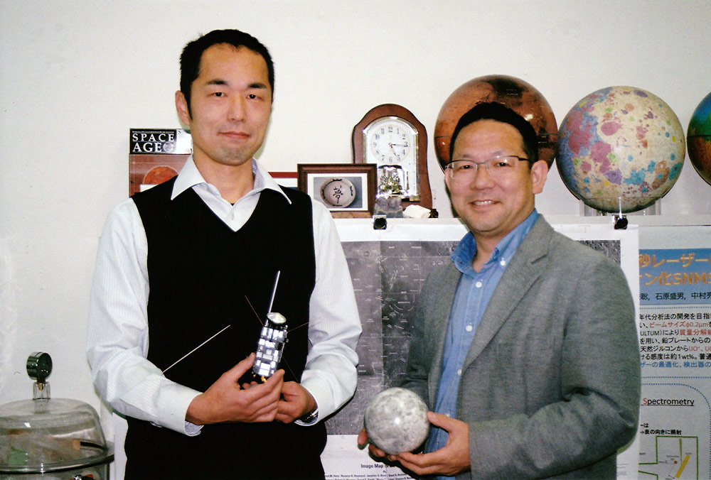 「かぐや」の模型を持つ横田さん（左）と月の模型を持つ寺田さん（右）