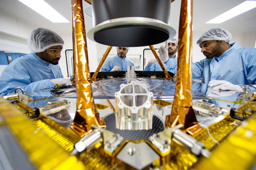 مجموعة من المهندسين يناقشون الخطوات الإضافية لتفكيك حاجز الواقي الشمسي للمركبة الفضائية لإجراء المزيد من الفحص.