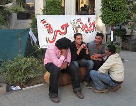 
الطلاب المشاركون في اعتصام احتجاجي بجامعة القاهرة يعلقون لافتة، مكتوب عليها 