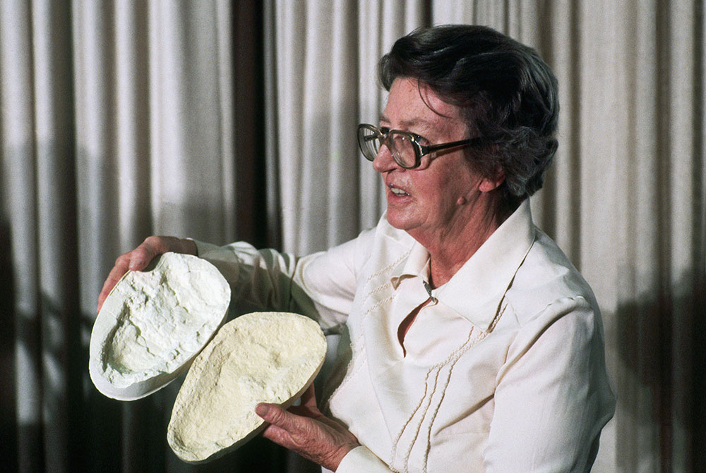 ヒト族の足跡の型を手に、ラエトリでの行跡「G」の発見について発表するメアリー・リーキー。1979年3月21日、米国ワシントンD.C.にて。