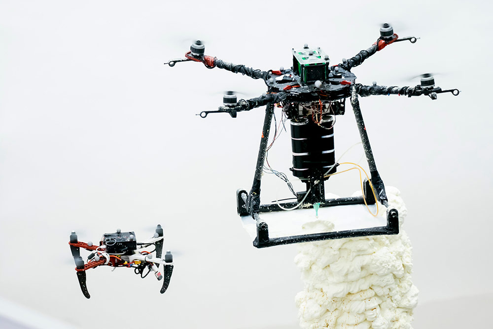 飛行しながら3D印刷を行うBuilDrone(右)と、建造物の品質を評価するScanDrone(左)。