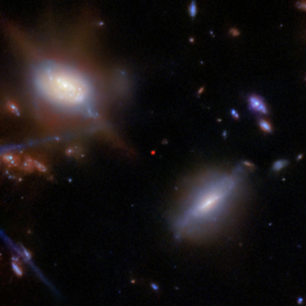 JWSTの近赤外線カメラが捉えた深宇宙。中央の小さな赤い点は極めて遠方にある銀河である。