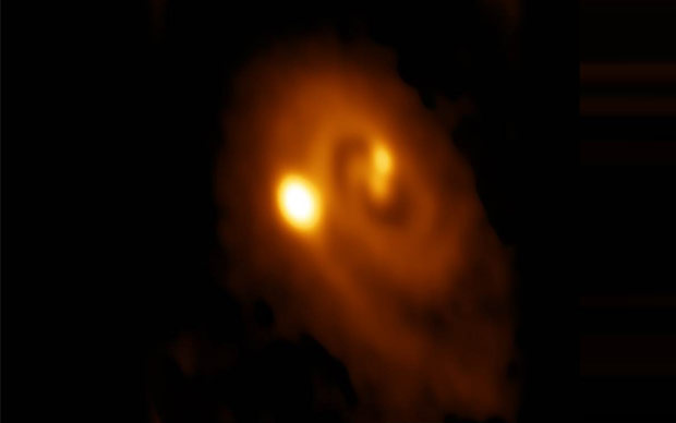 ALMA望遠鏡が捉えた三重原始星系L1448 IRS3B。3つの原始星を取り巻く渦巻き構造を持つ円盤が映し出されている。