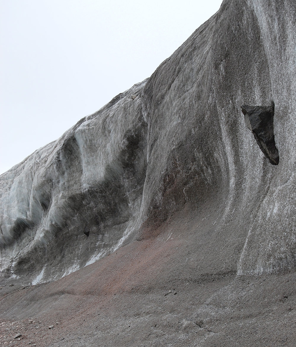 グリーンランド氷床の縁部の氷壁。長さ3 mほどの迷子石が氷に埋まっているのが見て取れる。